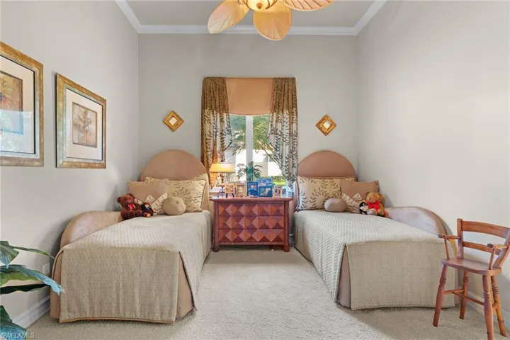 Carpeted bedroom with crown molding and ceiling fan
