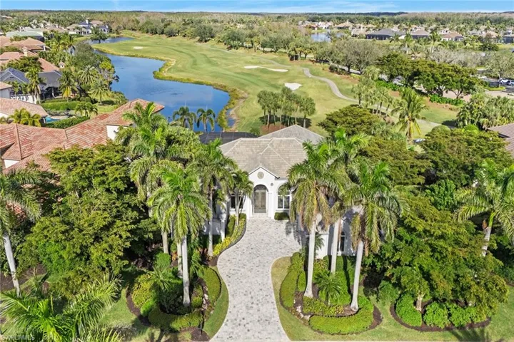Aerial perspective of suburban area featuring a golf course and a large body of water