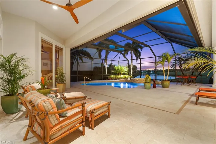 Outdoor pool featuring a patio area, glass enclosure, and a sunroom
