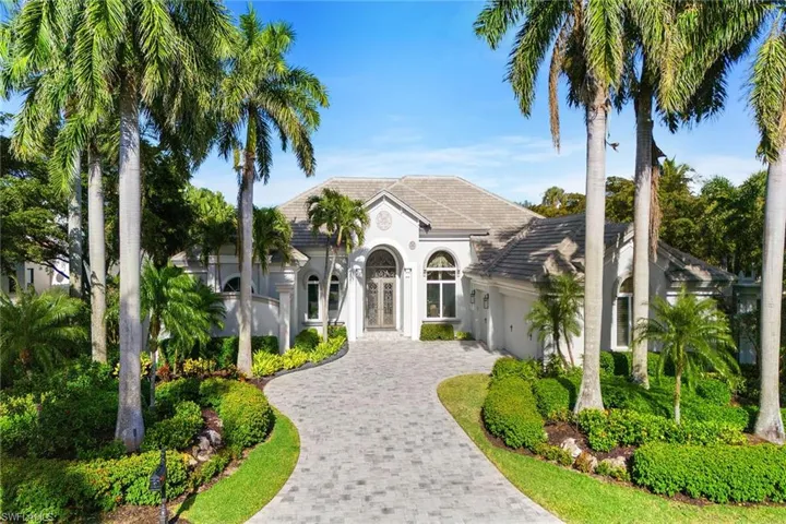 View of front of house featuring a tile roof, decorative driveway, an attached garage, stucco siding, and french doors