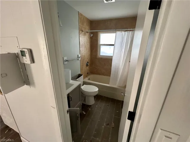 Full bathroom with shower / bath combo, vanity, and toilet
