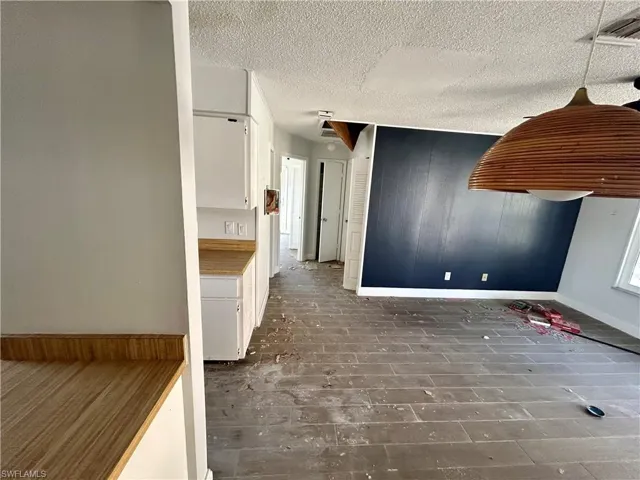 Kitchen featuring white cabinetry and a textured ceiling