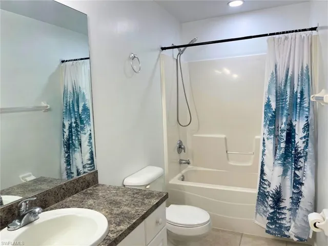 Full bathroom with vanity, tile patterned floors, and shower / bathtub combination with curtain