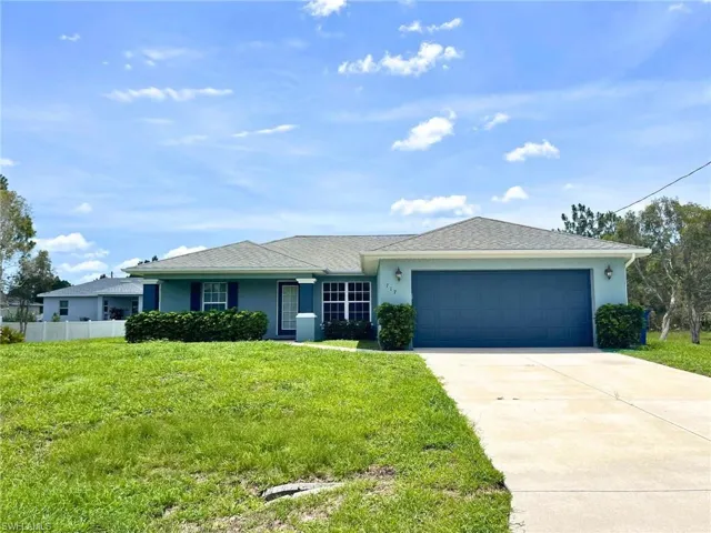Single story home with an attached garage, stucco siding, and driveway