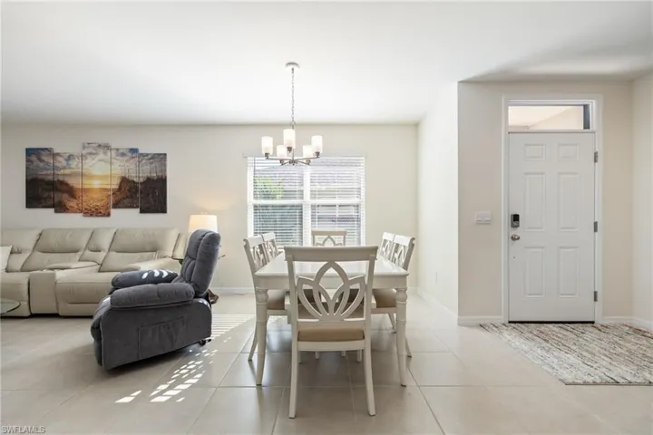 Dining room with a chandelier and light tile flooring