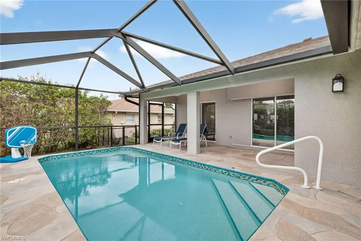 Pool with covered outdoor living space and screened lanai