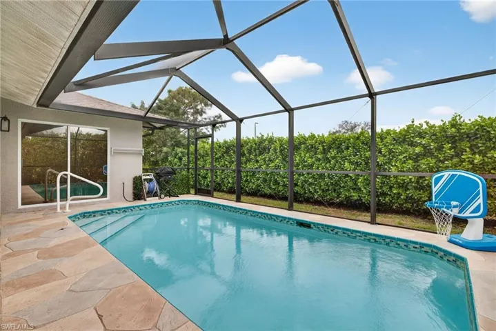 Pool with covered outdoor living space and screened lanai
