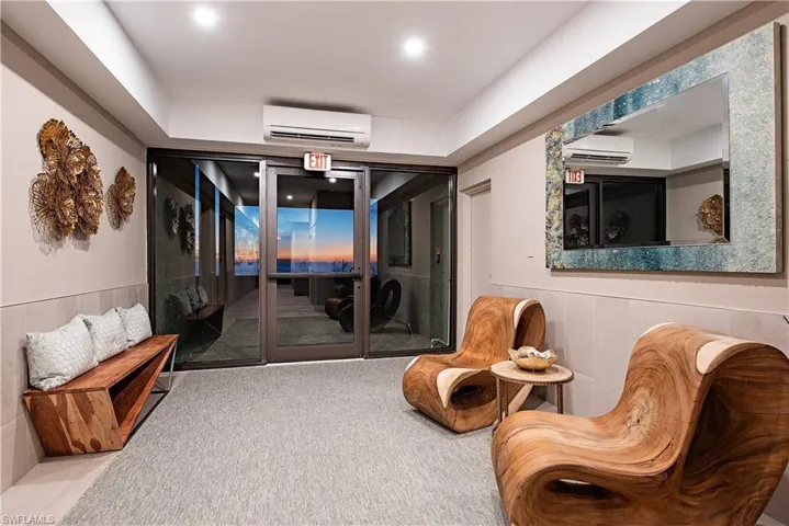 Sitting room featuring light carpet and a wall unit AC