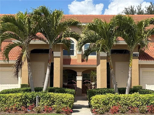 View of building exterior featuring an attached garage & Front Courtyard