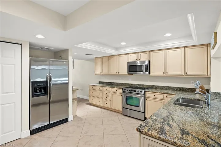 Kitchen featuring a tray ceiling, and appliances with stainless steel finishes