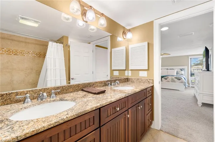 Bathroom featuring ensuite bath, double vanity