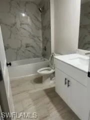 Full bathroom with tiled shower / bath, toilet, and vanity
