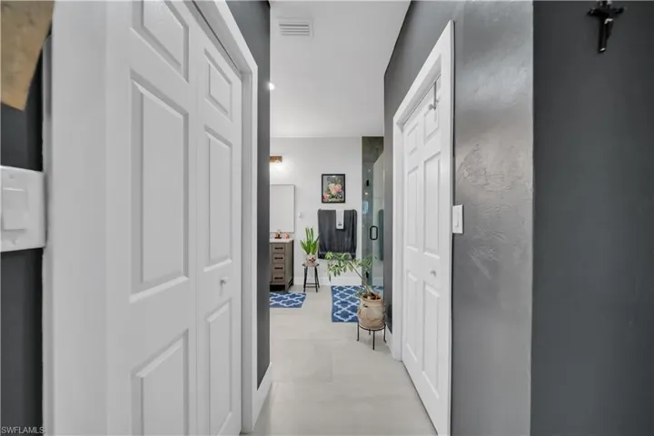 Hallway featuring white bi-fold doors and dark gray walls
