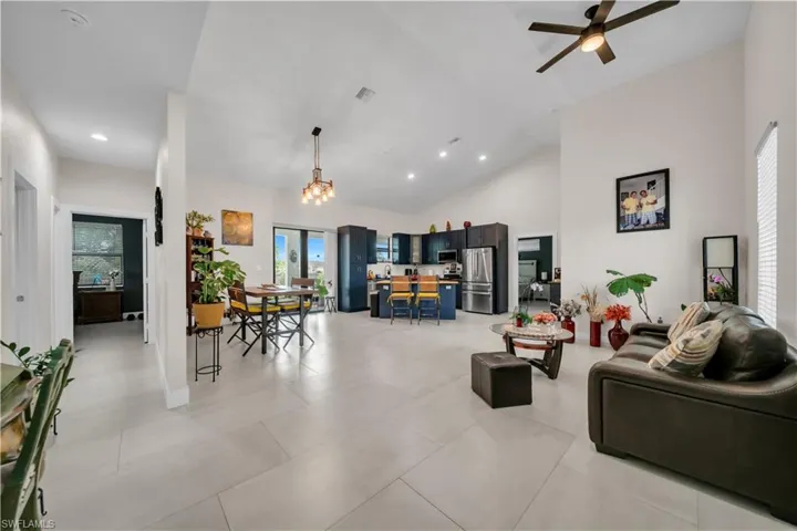 Vaulted ceilings define this open-concept interior featuring light-toned tile flooring throughout