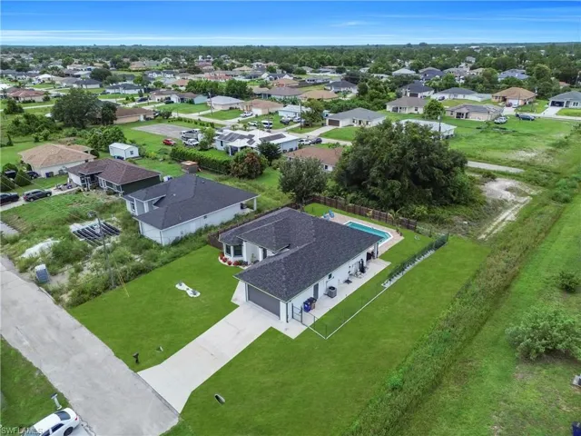 Contemporary single-story residence featuring a dark shingle roof and a light-colored exterior