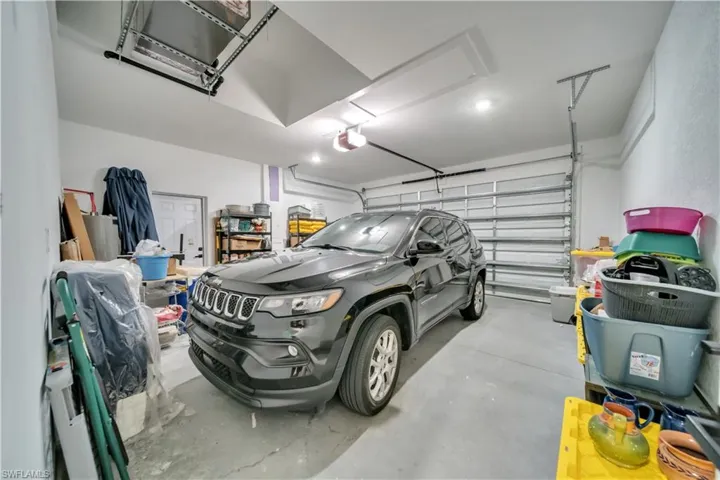 Two-car garage featuring a concrete floor, white walls, and an overhead door
