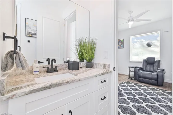 Bathroom featuring vanity, wood finished floors, and ceiling fan