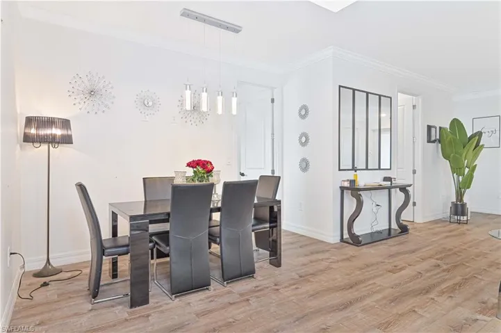 Dining area featuring wood finished floors and ornamental molding