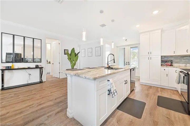 Kitchen with light wood-style flooring, crown molding, french doors, white cabinets, and recessed lighting