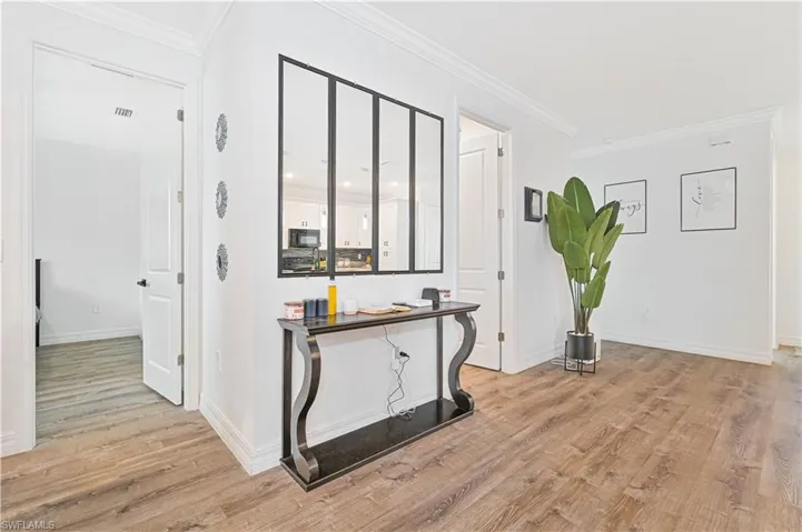 Hall featuring light wood-style flooring and ornamental molding