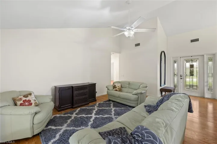 Living room featuring high vaulted ceiling, ceiling fan, and hardwood / wood-style floors