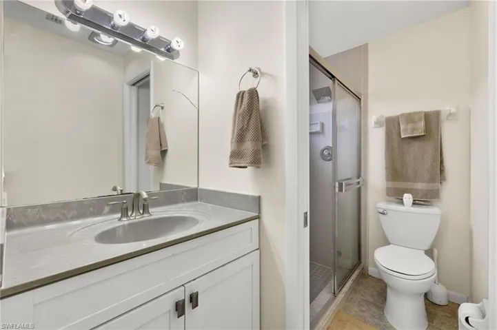 Bathroom featuring vanity, an enclosed shower, tile patterned flooring, and toilet