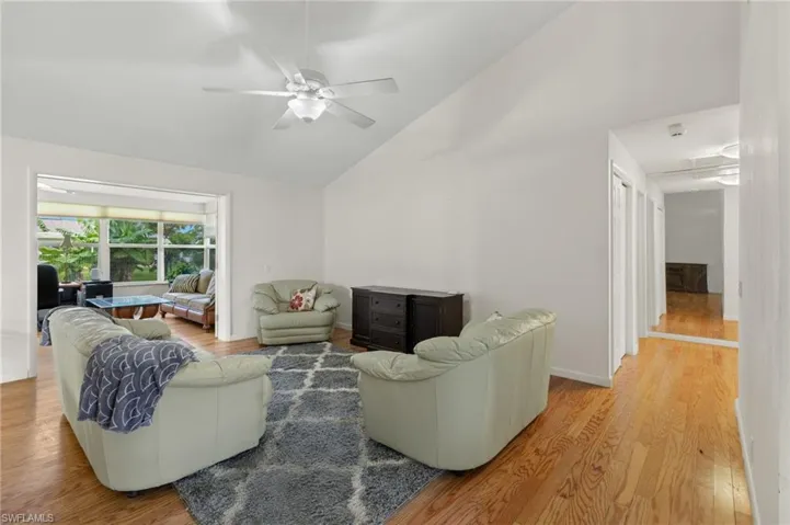 Living room featuring light hardwood / wood-style flooring, ceiling fan, and high vaulted ceiling