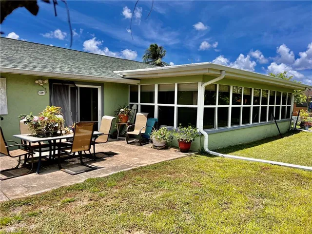 Rear view of property featuring a patio and a lawn