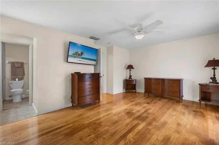 Unfurnished bedroom featuring light hardwood / wood-style floors, connected bathroom, and ceiling fan