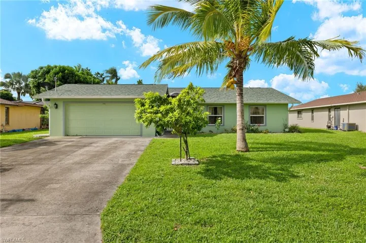 Ranch-style home with a garage, central AC, and a front yard
