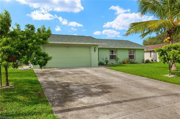 Single story home with a garage and a front yard