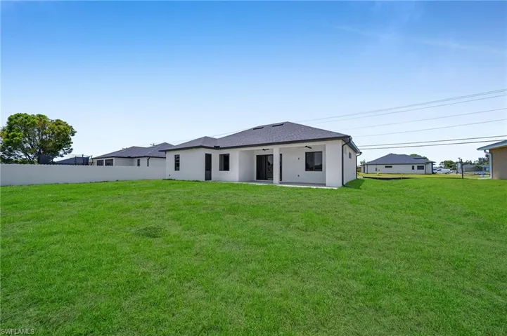 Back of property featuring a ceiling fan and a patio area