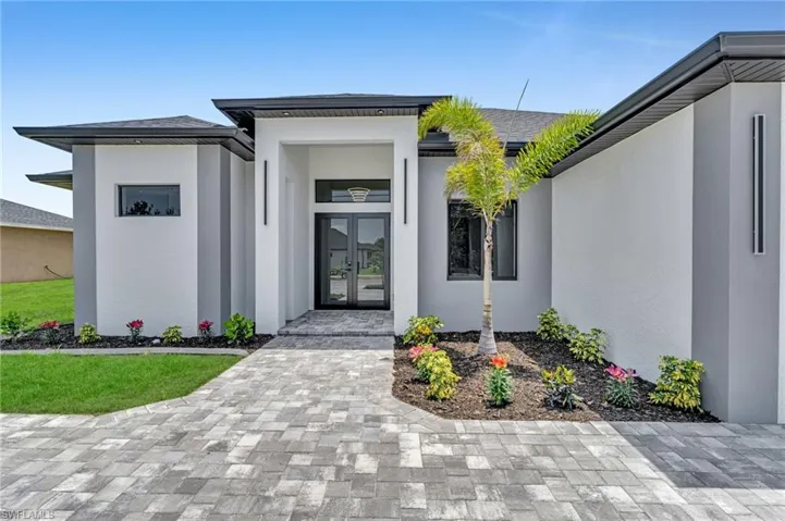 Doorway to property featuring french doors and stucco siding