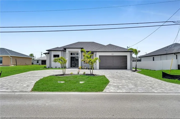 View of front of home featuring decorative driveway, stucco siding, and an attached garage