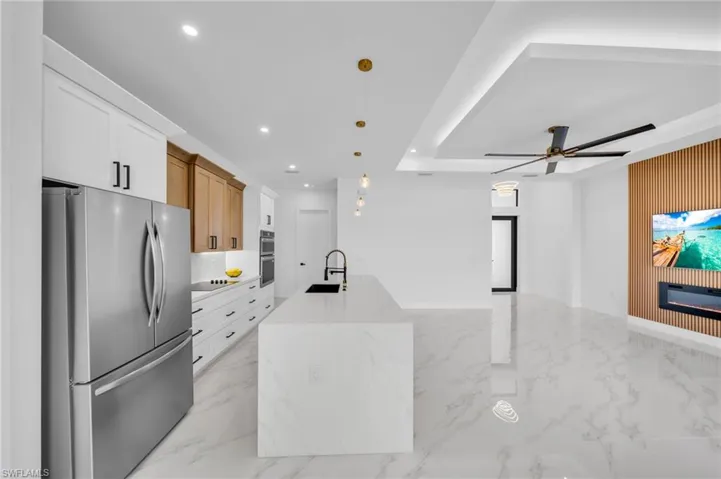 Kitchen featuring appliances with stainless steel finishes, a sink, light marble finish floors, ceiling fan, and recessed lighting