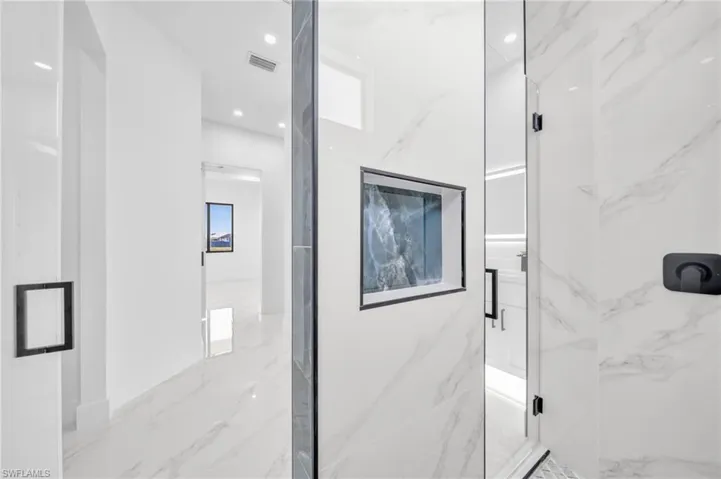 Full bathroom with a marble finish shower and marble finish floors