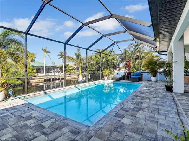 View of swimming pool with a lanai, a patio, and a water view