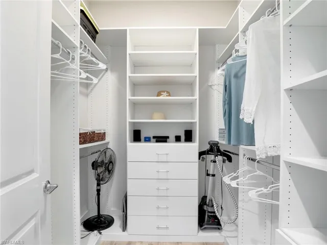 Spacious closet with light hardwood / wood-style flooring
