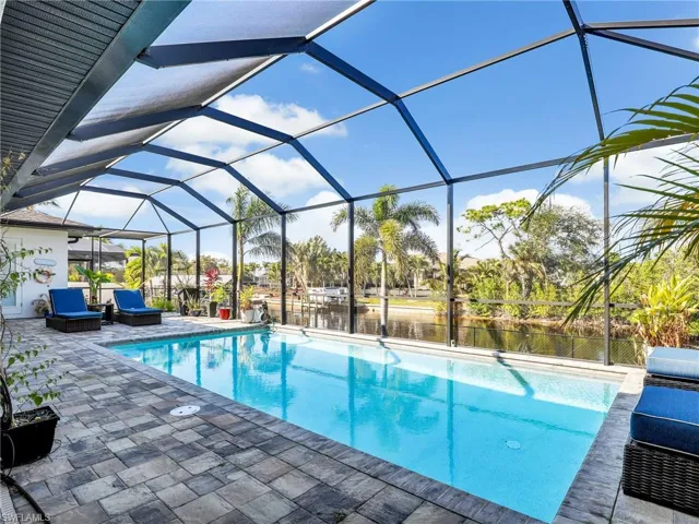 View of swimming pool with a lanai, a patio area, and a water view
