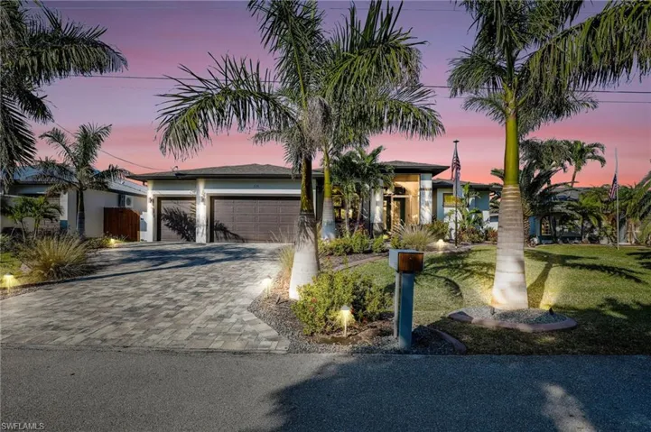 View of front of house featuring a garage and a lawn