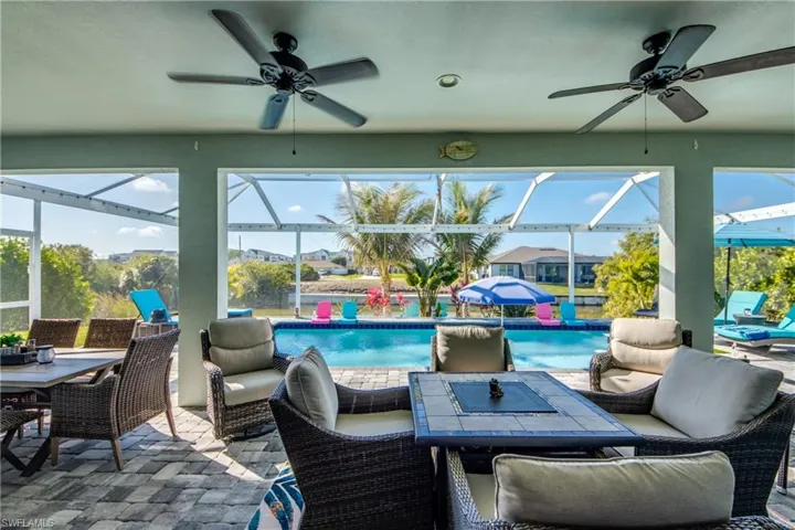 View of patio featuring a lanai, an outdoor living / dining area, a sunroom, and an outdoor pool
