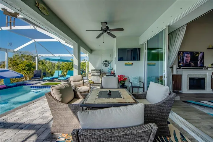 View of patio featuring an outdoor pool, ceiling fan, a sunroom, a lanai, and outdoor seating
