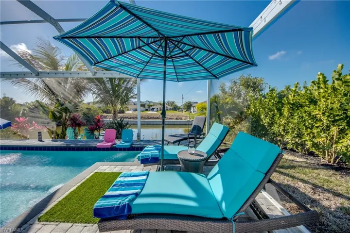View of patio / terrace with an outdoor pool, a water view, and a lanai