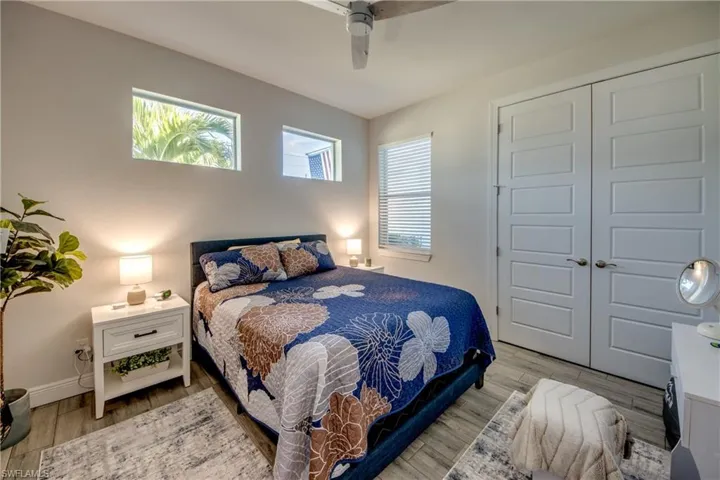 Bedroom with light wood-style flooring, a closet, and ceiling fan