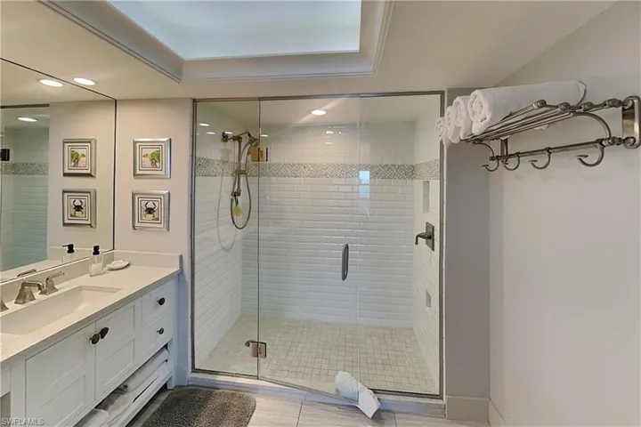Walk-in shower with clear glass enclosure and white subway tile surround