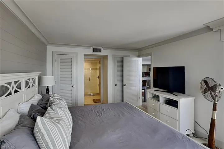 Bedroom featuring a decorative headboard and shiplap accent wall