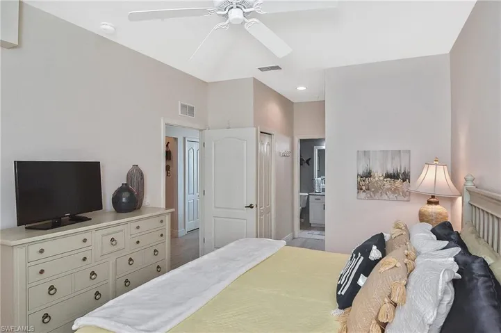 Bedroom featuring light wood-style flooring, connected bathroom, ceiling fan, and a closet