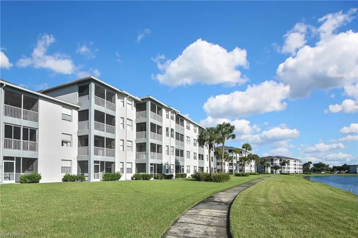 Surrounding community with view of golf course, a water view, and view of scattered trees