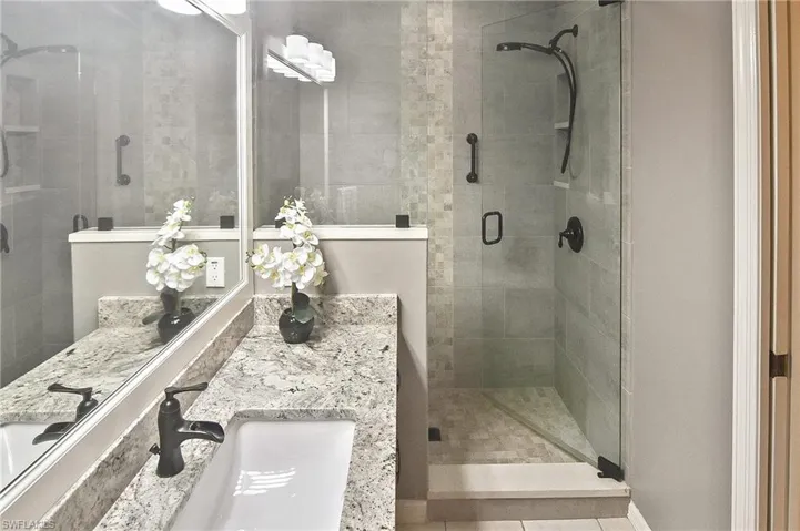 Bathroom featuring vanity, a shower stall, and light tile patterned floors