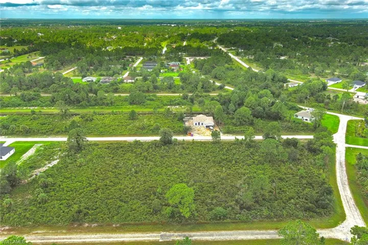 Aerial view of property's location with a heavily wooded area